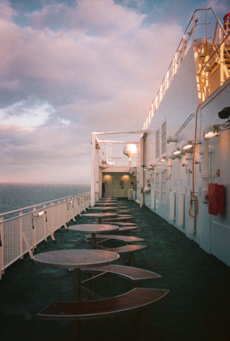 Outside picnic tables on a ferry at sunset